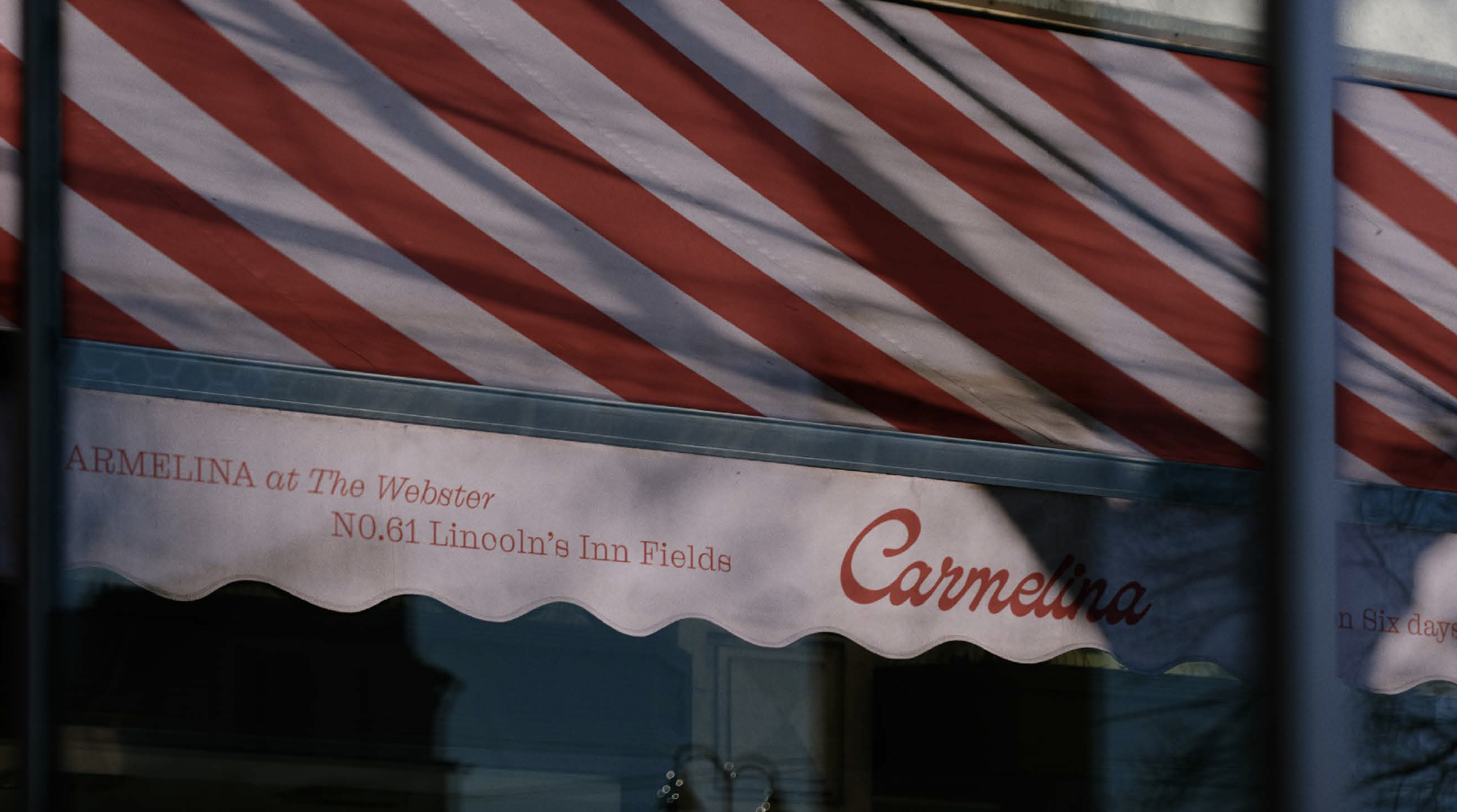 A shop awning with red and white stripes displays the text Carmelina at The Webster NO.61 Lincolns Inn Fields and Carmelina in cursive, set near Covent Garden. Vertical shadows fall across the image.