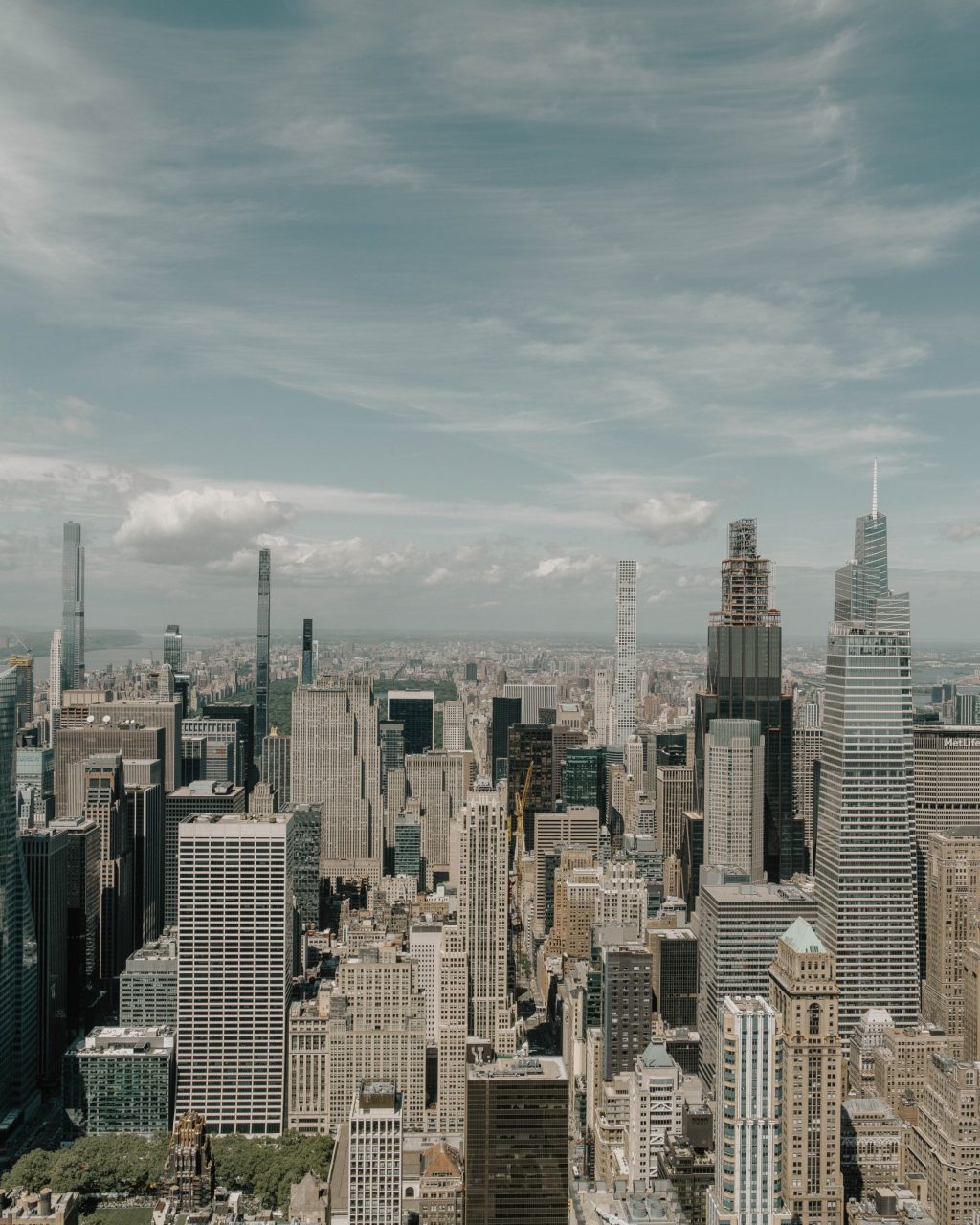 Aerial view of a city skyline with many tall skyscrapers under a partly cloudy sky, showcasing modern architecture and bustling urban energy near The Webster.