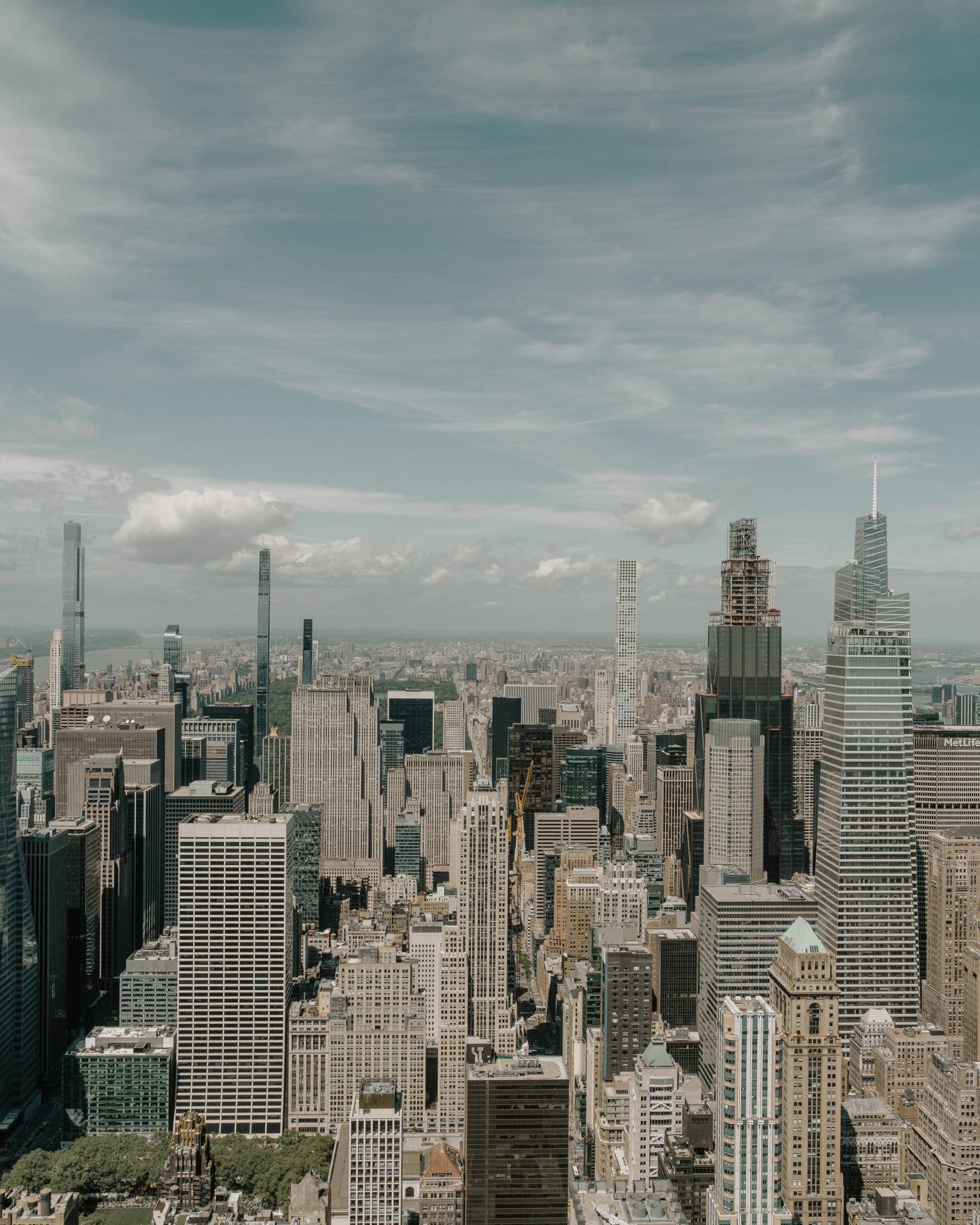 Aerial view of a city skyline with many tall skyscrapers under a partly cloudy sky, showcasing modern architecture and bustling urban energy near The Webster.