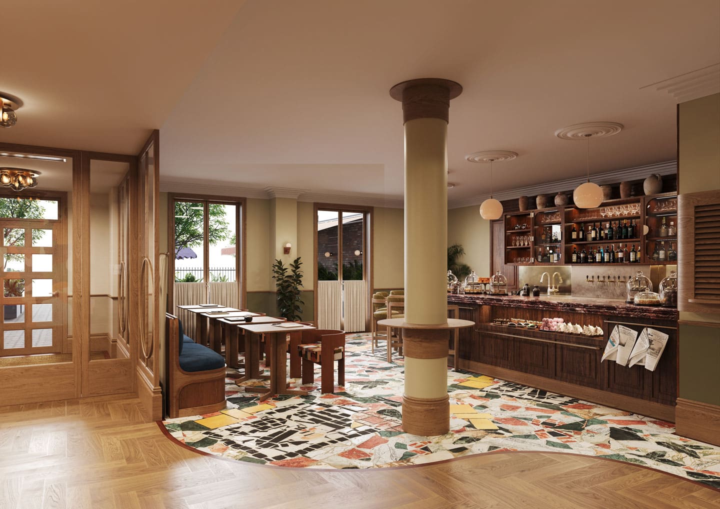 A cozy café interior at The Webster with wooden furniture, tables and chairs, a colorful tiled floor, a central pillar, a counter with pastries, shelves of bottles, and large windows letting in natural light.